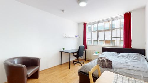 伦敦Superb Studio Apartment的一间卧室配有一张床、一张桌子和一把椅子