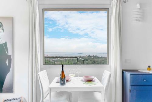 索亚诺德拉戈[Piscina Panoramica] - La Casa Volante的白色的桌子和椅子,设有大窗户