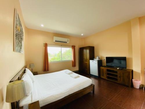 Ban Wang Takhrai班苏安昆亚依旅馆的卧室配有白色的床和电视。