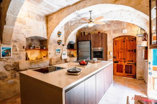 MunxarMatli Farmhouse, your stunning Gozo getaway.的一个大厨房,带有大石墙