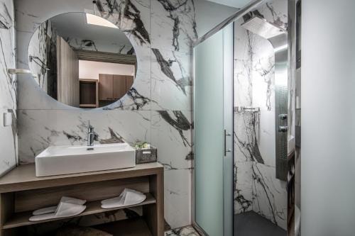 古瓦伊Crete Resort Sea Side Suites "Adults Only" by Checkin的一间带水槽和镜子的浴室
