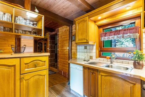 LaufBlockhaus Günther und Brigitte Serr的厨房配有木制橱柜、水槽和窗户。