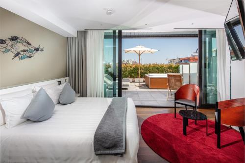 利尼亚诺萨比亚多罗Hotel Monaco的一间带一张床和一张书桌的卧室以及一个阳台