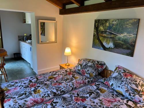 森特贝克卡尔洛Búzavirág Apartman的卧室配有一张床,墙上挂有绘画作品