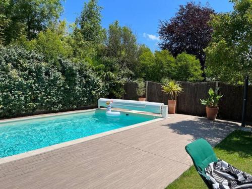 巴约讷Belle maison familiale Basque的庭院内带长凳的游泳池