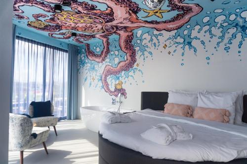 艾默伊登劳乌安娜德卡德酒店的卧室配有一张大床,墙上涂有章鱼