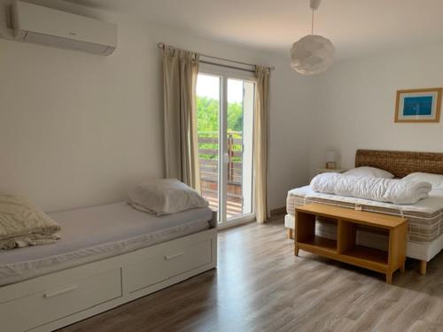 阿雷斯Villa Le Chêne Vert的一间卧室设有两张床和滑动玻璃门