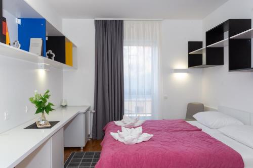 斯普利特Rooms Kampus的配有一张粉色毯子的床的房间