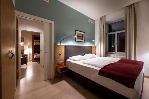 博尔扎诺斯蒂尔格斯卡拉酒店的一间卧室配有一张带红色毯子的大床