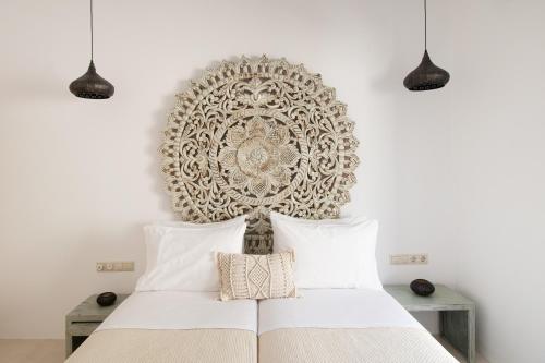 伊奥斯乔拉Youtopia Ios Villas的卧室配有白色的床和大型艺术墙