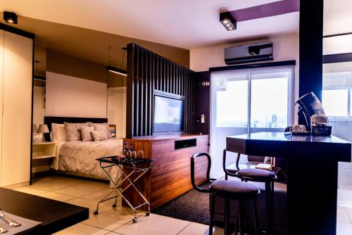 索罗卡巴Loft Campolim的一间卧室配有一张床和一张书桌及电视