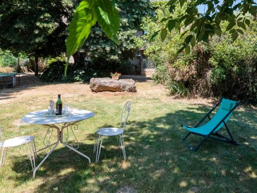 Bourg-Archambault蒂莫西花园别墅的院子里的桌椅和一瓶葡萄酒