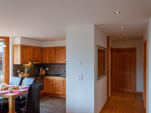 南达Apartment Les Cimes Blanches B 401 by Interhome的一间带木制橱柜和桌子的厨房以及一间用餐室