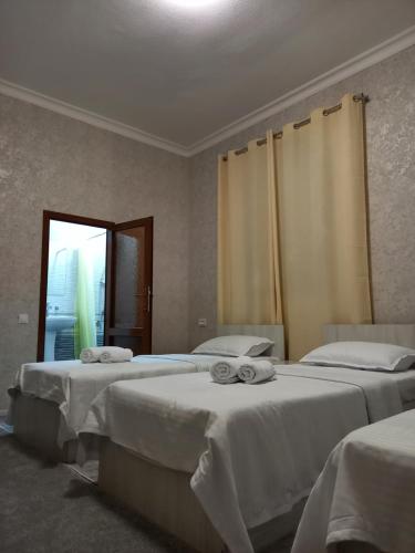 撒马尔罕Guest house Zebiniso的一间设有两张床铺和毛巾的房间