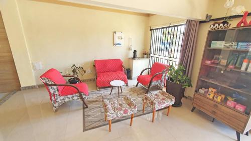 康塞桑达巴拉Pousada Beth Shalom的客厅配有红色椅子和桌子