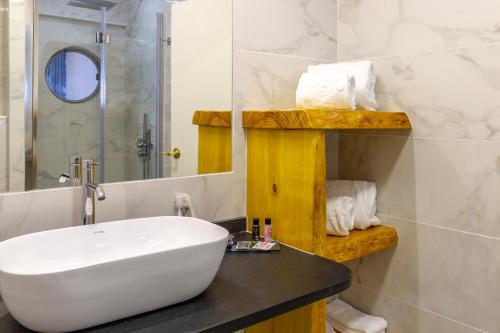里斯本AS葡京酒店 的浴室设有白色水槽和镜子