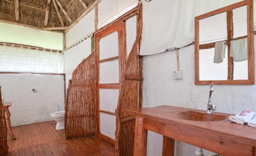 卡塞斯Kazinga Wilderness Safari Camp的一间带木制水槽和卫生间的浴室