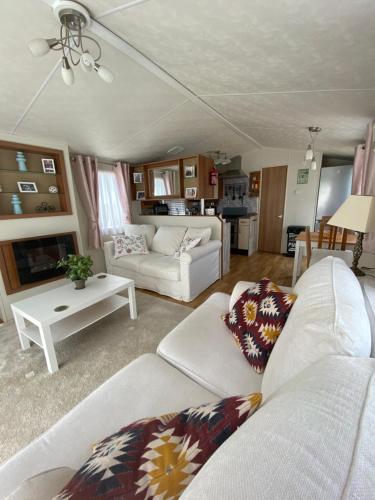 阿尔豪林德拉托里Malaga Monte Parc的一间带2张白色沙发的客厅和一间厨房