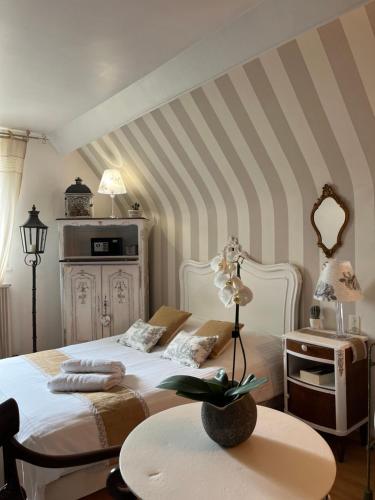 色当VILLA NOTRE DAME face au Château fort的卧室配有白色的床和桌子