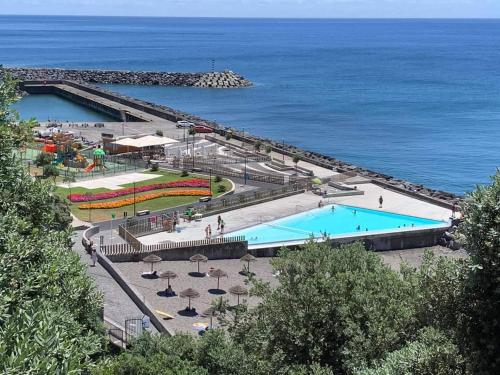 波瓦桑Sons da Ribeira的毗邻大海的大型游泳池