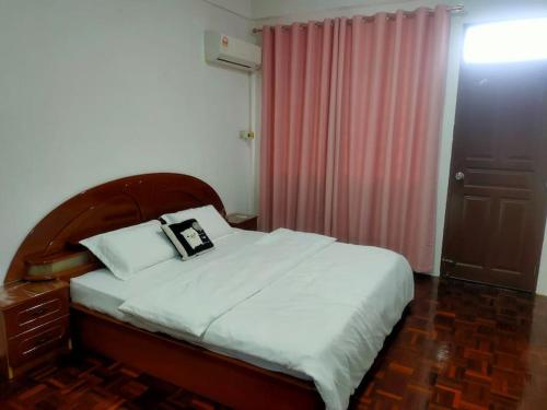 诗巫Sibu kulas homestay的一间卧室配有一张床和粉红色窗帘