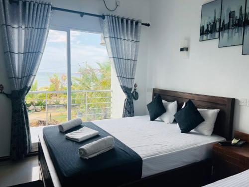 亭可马里里约纳海滩酒店的一间卧室设有一张床和一个大窗户