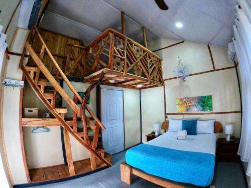蓬塔露奇亚Rustic House Punta Rucia的一间卧室设有双层床和螺旋楼梯。