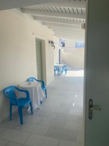 纳克索乔拉Asiminas的白色的客房配有蓝色的椅子和桌子