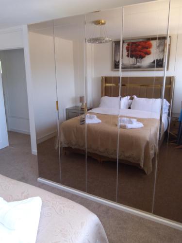 巴恩斯特珀尔Hill's View的一间卧室设有一张床和玻璃墙
