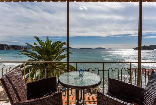 托隆Hotel Assini Beach Tolo的一个带桌椅的庭院和大海