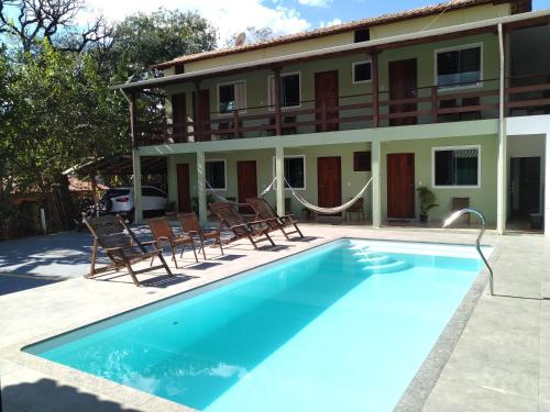 西波山Estadia cipó的一座游泳池位于酒店前,设有椅子和一座建筑