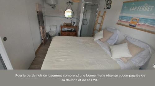 梅里尼亚克Mignon petit appartement indépendant的卧室配有一张带白色床单和枕头的大床。