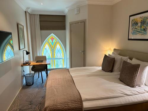 克里斯蒂娜港索克斯洛特酒店的一间卧室配有一张床、一张书桌和一个窗户。