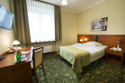 亚沃日诺布罗剑酒店的配有一张床和一张书桌的酒店客房