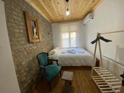 伊斯坦布尔Balat Historical Luxury House的一间卧室配有一张床和一把绿色椅子