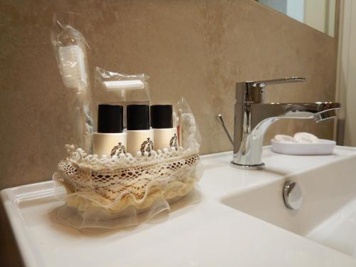 佛罗伦萨Chic Stay Boutique Apartments的浴室水槽上装有化妆品的容器