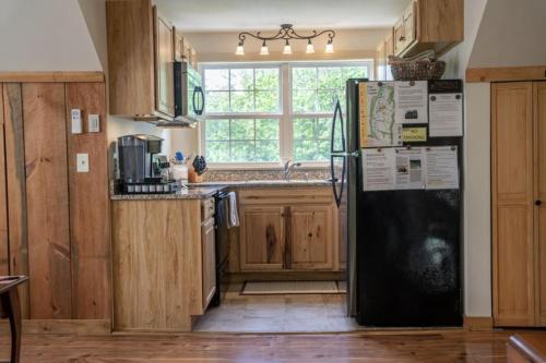 卢雷Mockingbird Mountain Spa and Retreat的厨房配有黑色冰箱和窗户。