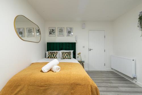 卡迪夫Exquisite Cardiff Apartments- with Garden Lounge & Games Room的一间卧室配有一张带黄色毯子的大床