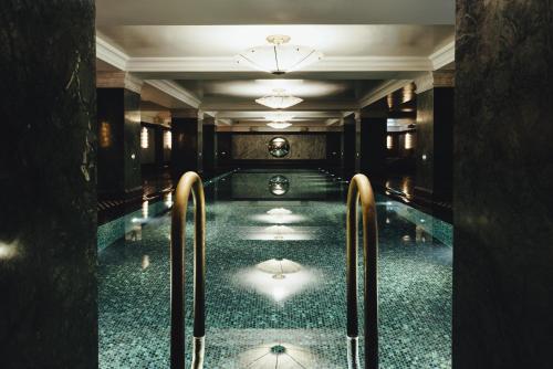 伦敦纳德酒店的一座建筑物内带两个金属栏杆的游泳池