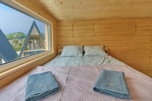 里沃Domki RWL的一间卧室配有带两个枕头的床和窗户