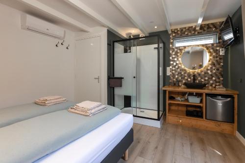 登堡Bed & Bike Schoudieck的一间卧室配有一张床、镜子和电视