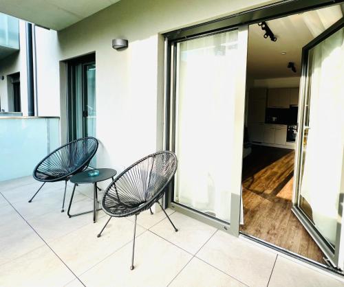 格拉茨APSTAY Serviced Apartments - Self Check-in的阳台配有2把椅子和1张桌子