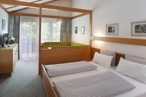 普夫龙滕快乐吉恩贝格公园式酒店的一间带两张床和浴缸的卧室