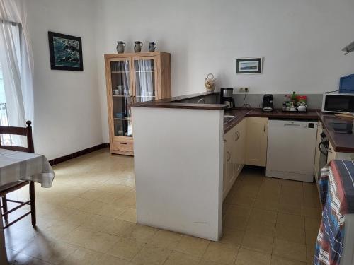 莱斯卡拉L'Escala - Pintor Massanet的一间厨房,在房间内有白色的岛屿