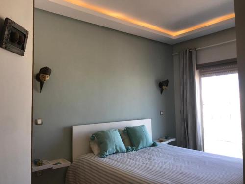 布兹尼盖Bouznika plage costa的一间卧室配有一张带蓝色枕头的大床