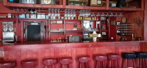Červená LhotaKratochviluv mlyn的餐厅里红色的酒吧,有红色的凳子