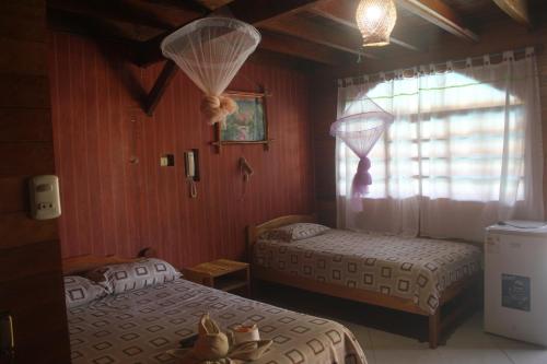 塔拉波托马德拉拉不拉达生态山林小屋的一间卧室设有两张床和窗户。