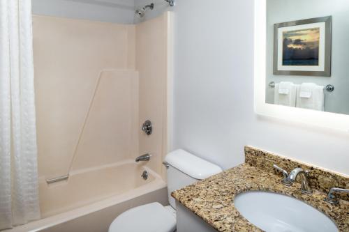 汉普顿海边阿什沃斯酒店的一间带水槽、浴缸和卫生间的浴室