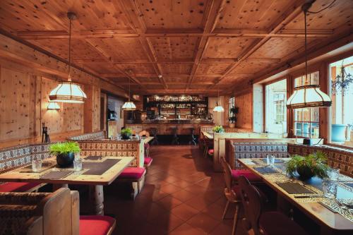 布列瑟农PLOSE Parkhotel & Residence的餐厅设有木制天花板和桌椅