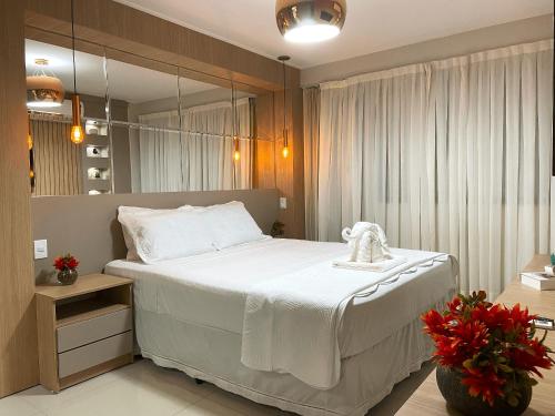 拉巴拉德纳圣米格尔Charmoso apto em Barra Bali - Destino BSM 108的卧室配有一张带镜子的白色大床
